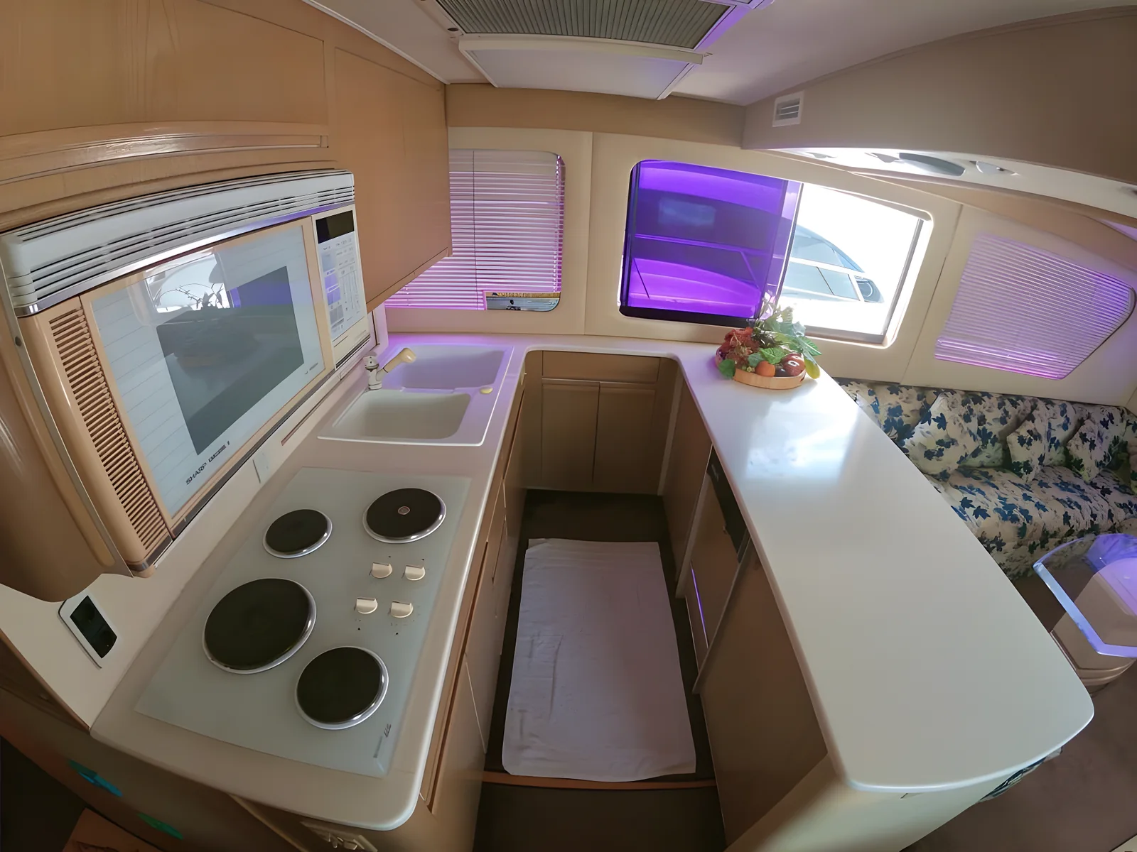 Cocina del yate Addie de 60 pies con estufa, microondas e iluminación ambiental.