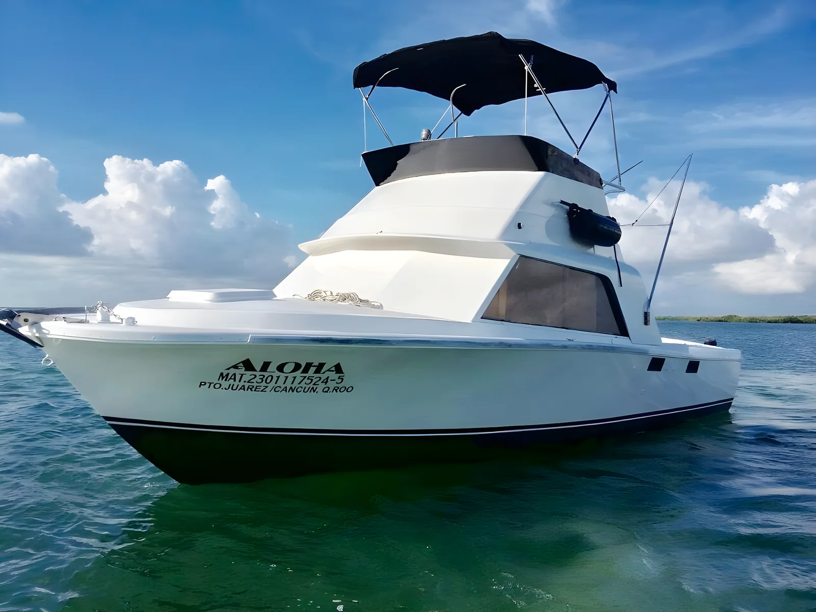 Vista de proa del yate Aloha 31ft anclado bajo un cielo parcialmente nublado.