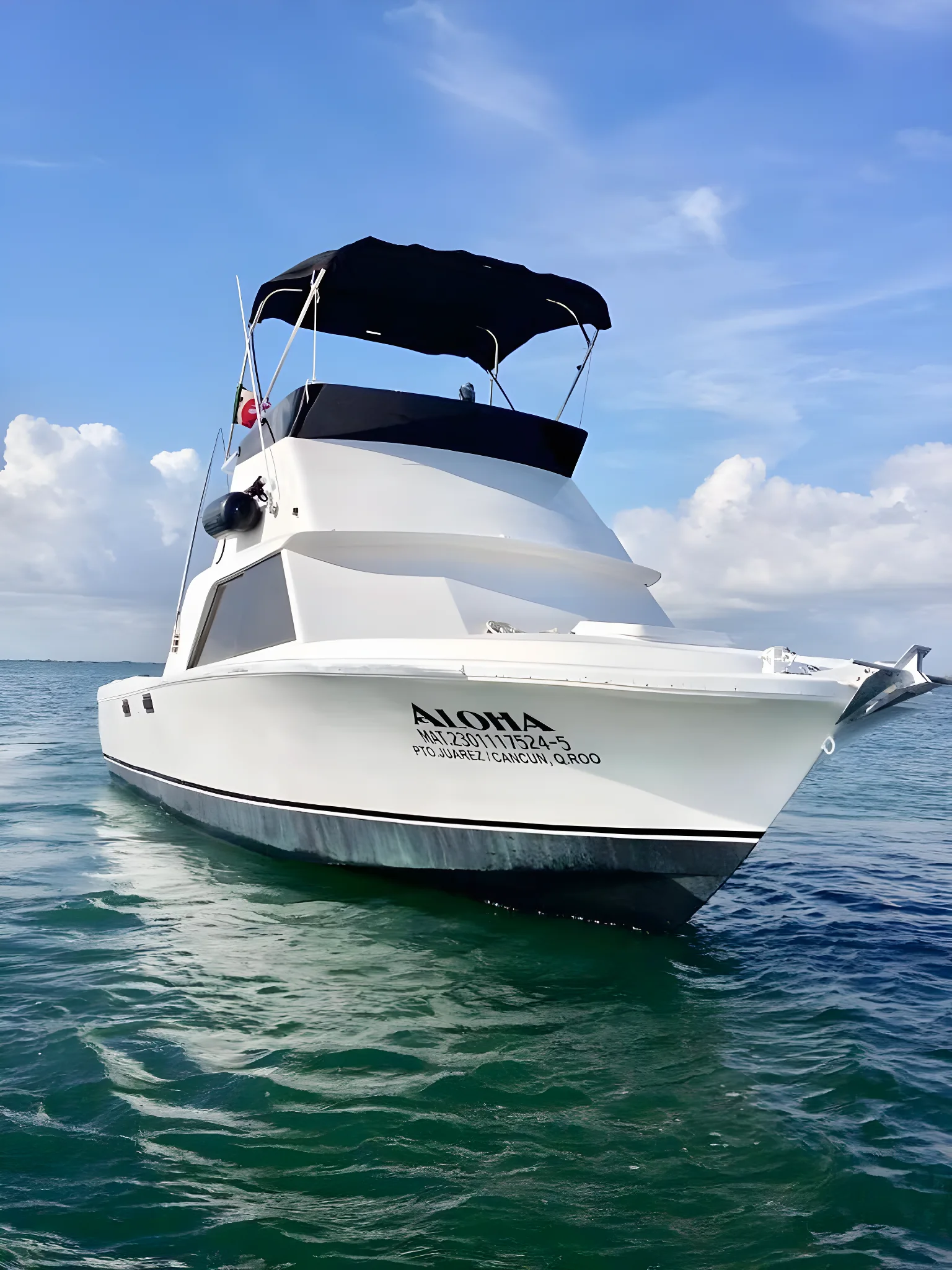 Vista frontal del yate Aloha 31ft anclado en aguas cristalinas.
