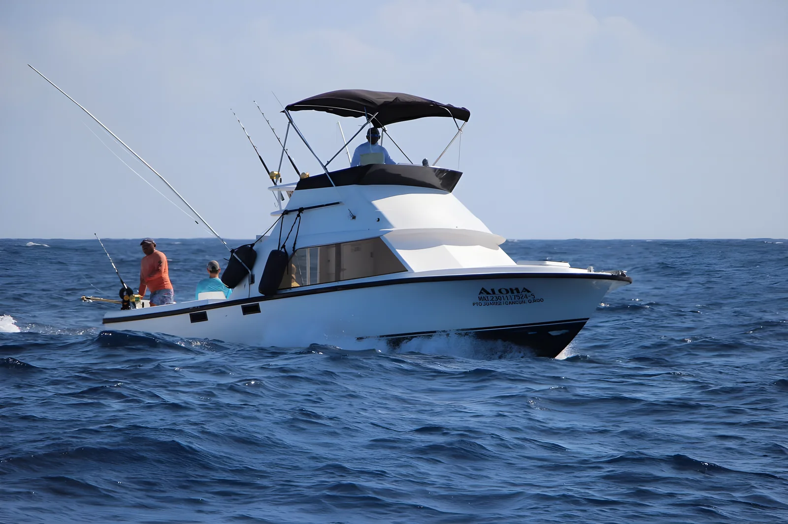 Vista lateral del yate Aloha 31ft navegando con pescadores a bordo.