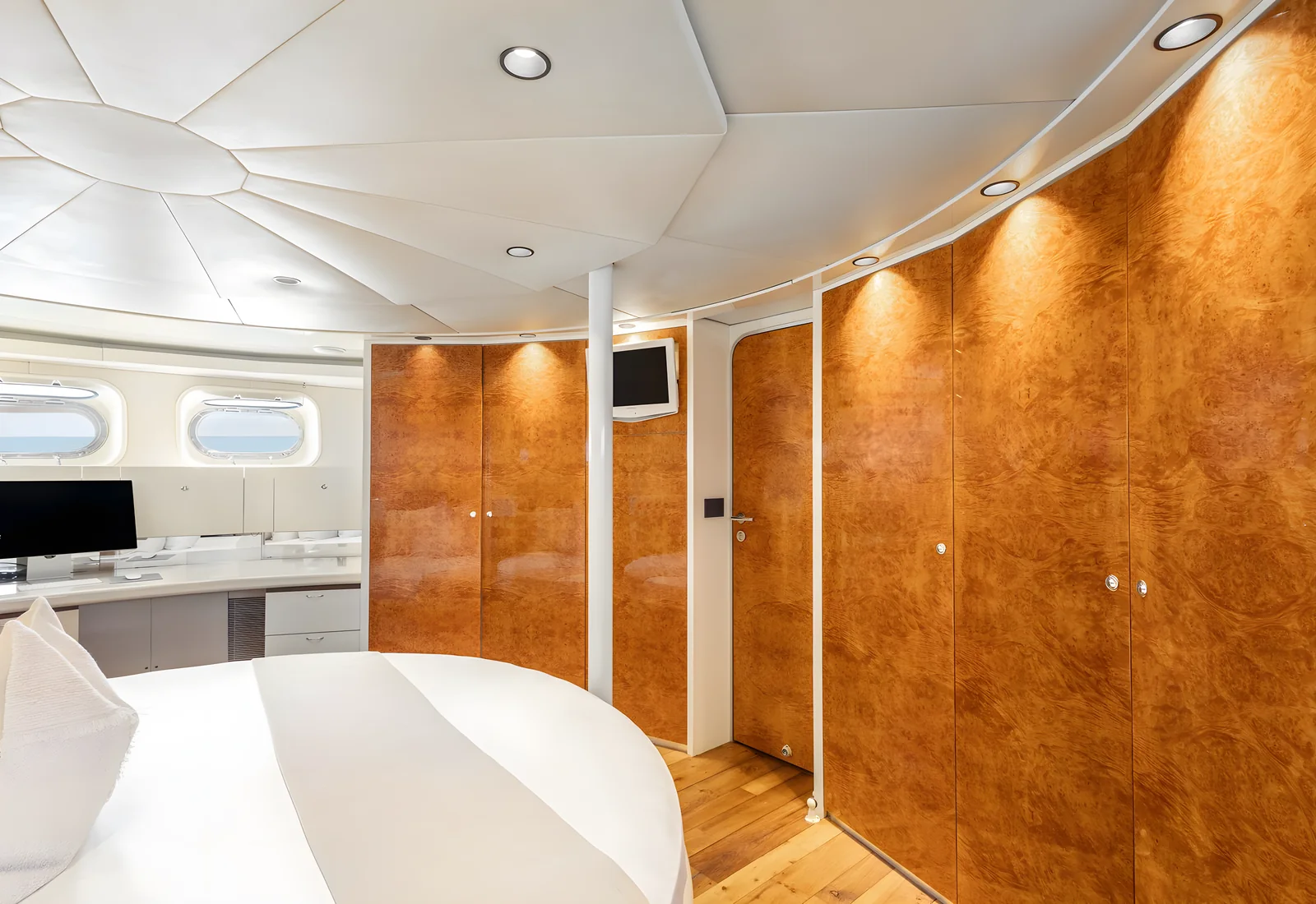 Cabina del yate Avalon con cama circular, paneles de madera y tocador.