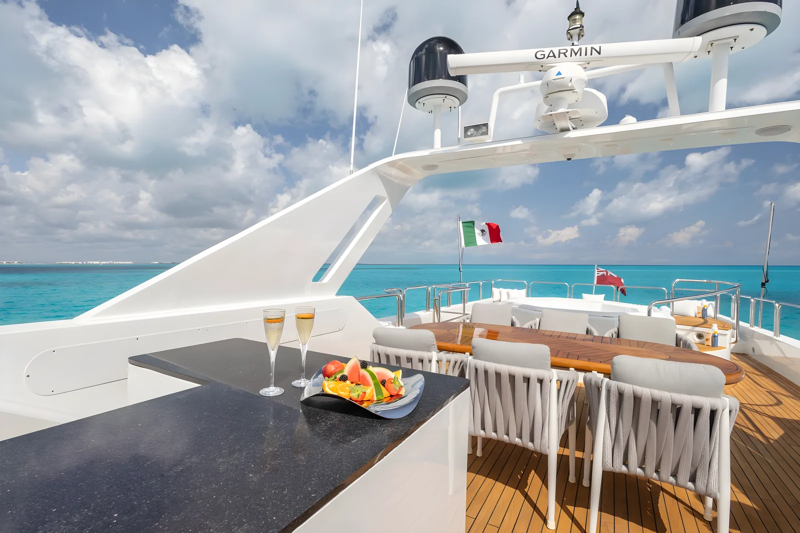 Zona de comedor en el flybridge del yate Avalon con barra y vistas al mar.