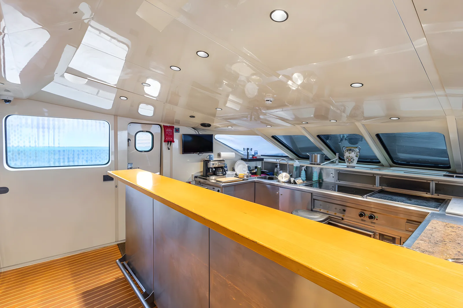 Cocina profesional del yate Avalon de 115 pies con barra de madera y equipos de acero inoxidable.