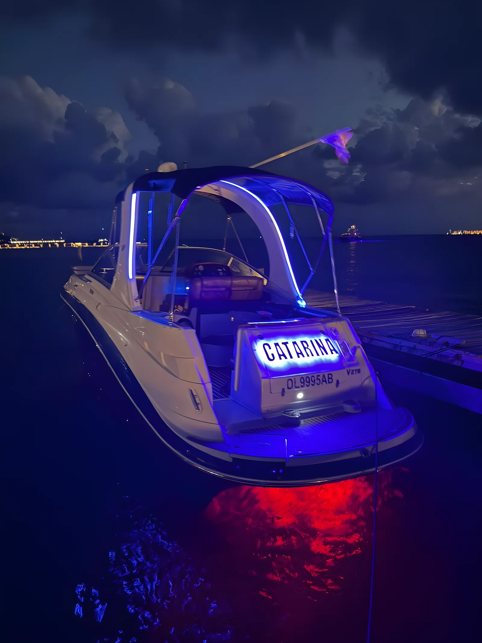 Popa iluminada del yate Catarina de 30 pies de noche amarrado en el muelle.
