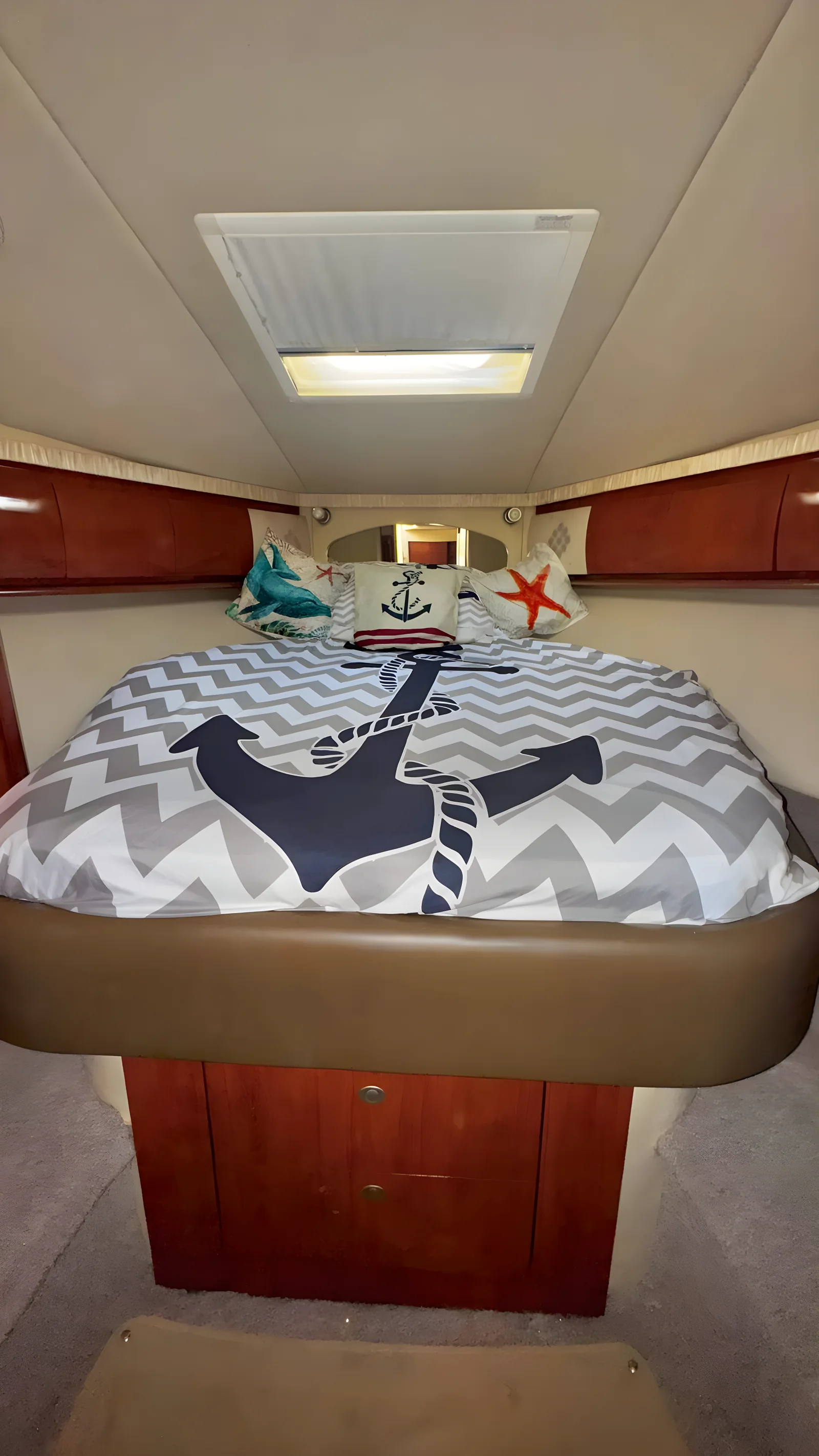 Camarote del yate Dolphin de 48 pies con cama doble, ropa de ancla y claraboya en el techo.