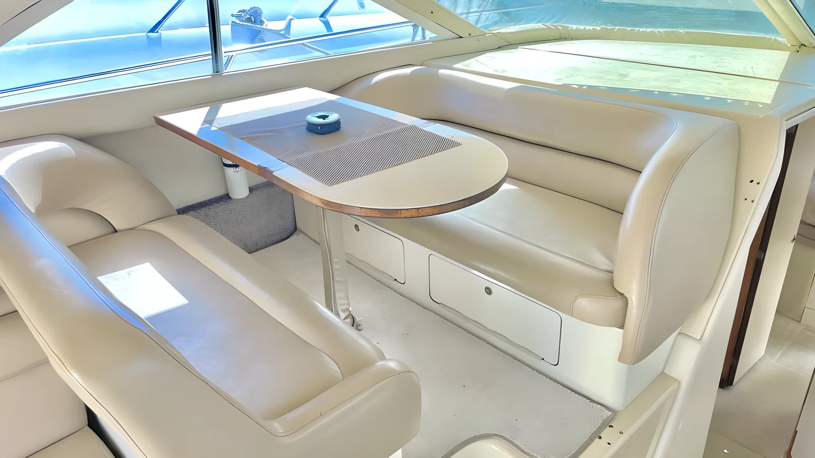 Comedor del yate Flycatcher de 46 pies con asientos en U de cuero color crema.