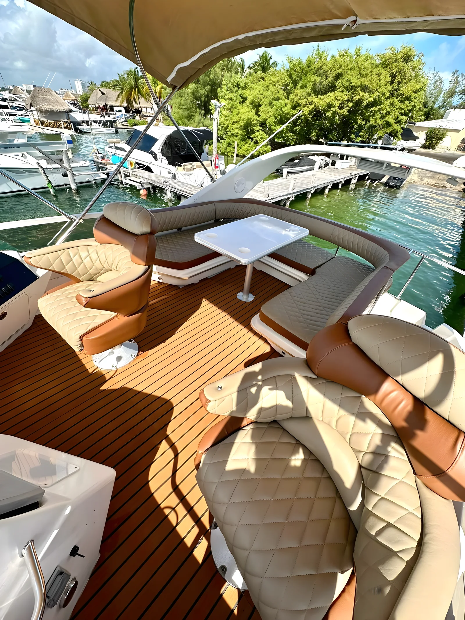 Lounge del flybridge del yate Flycatcher de 46 pies con asientos curvos bajo toldo.
