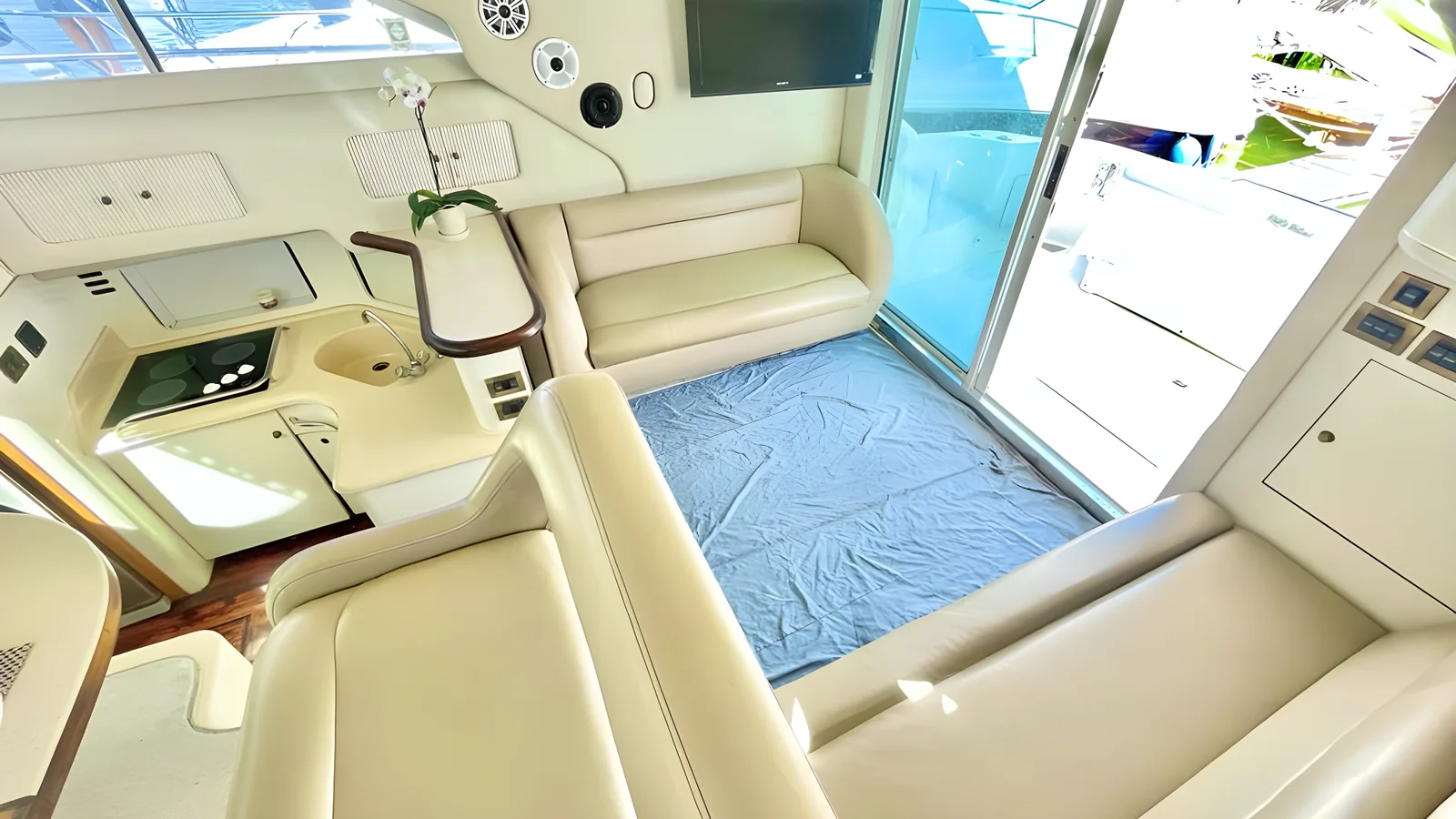 Salón y cocina del yate Flycatcher de 46 pies con sofás de cuero crema.