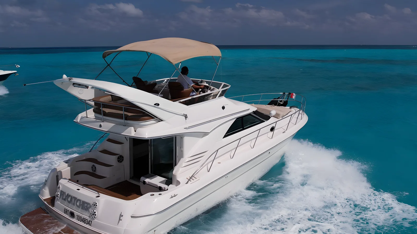 Vista de popa del yate Flycatcher de 46 pies navegando con su flybridge cubierto.