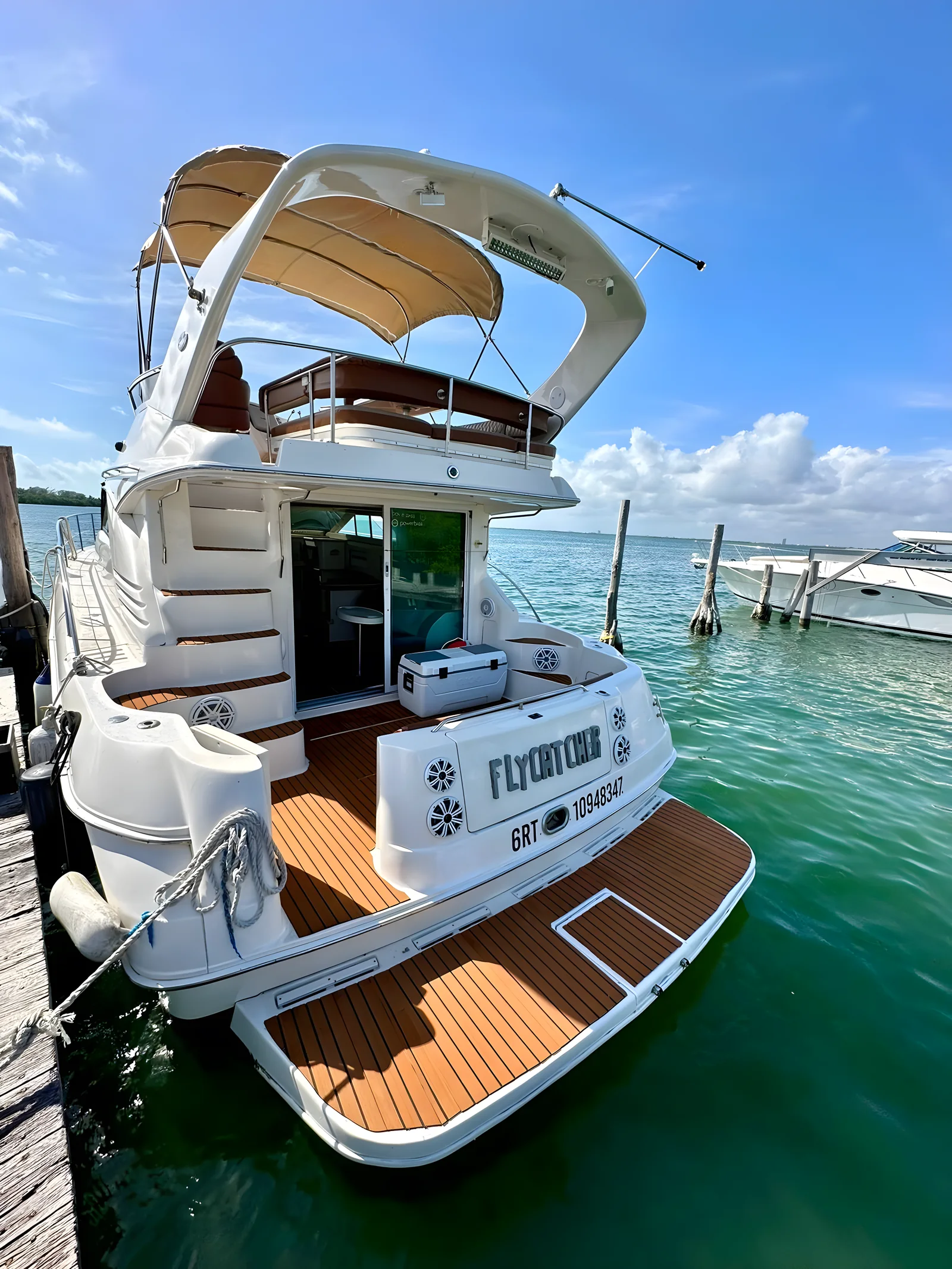 Popa del yate Flycatcher de 46 pies amarrado con plataforma de baño y flybridge.