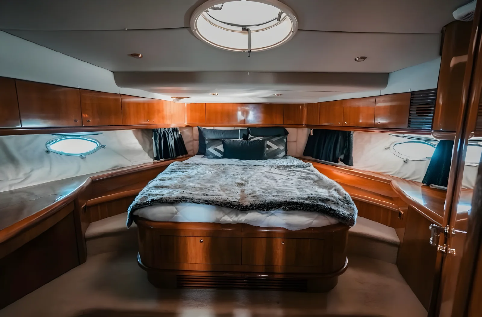 Cabina principal del yate Gambler de 75 pies con cama central y madera.