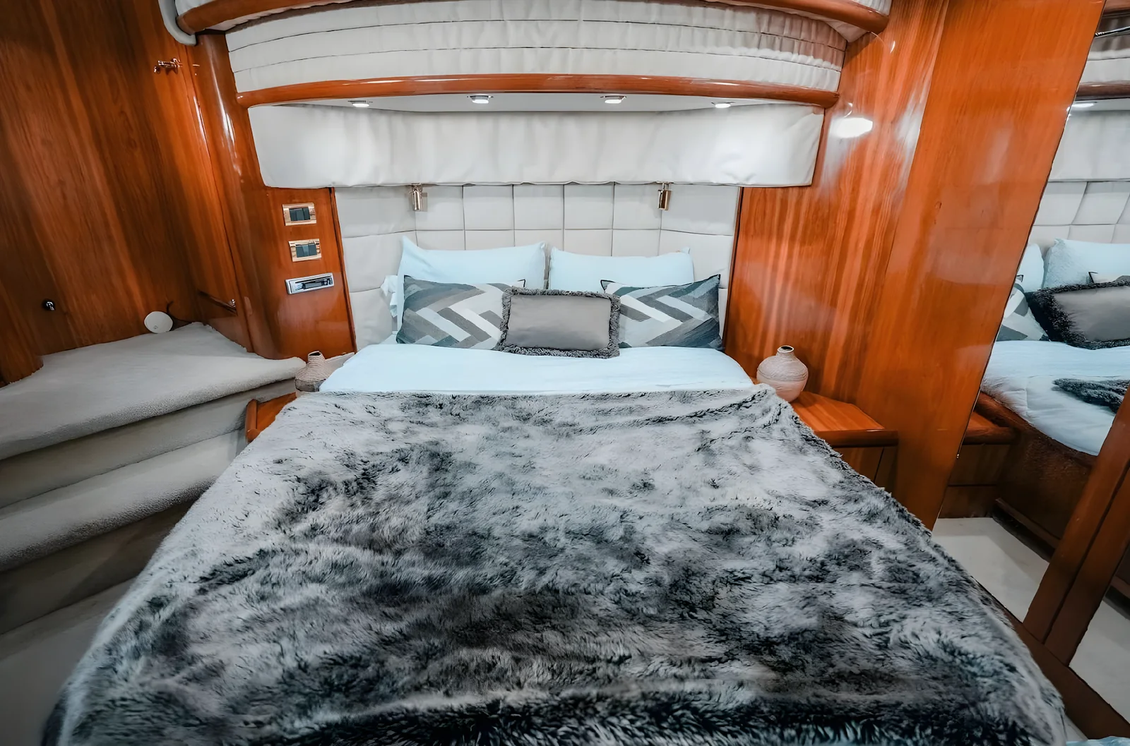 Cabina principal del yate Gambler de 75 pies con cama adornada y acabados de madera.