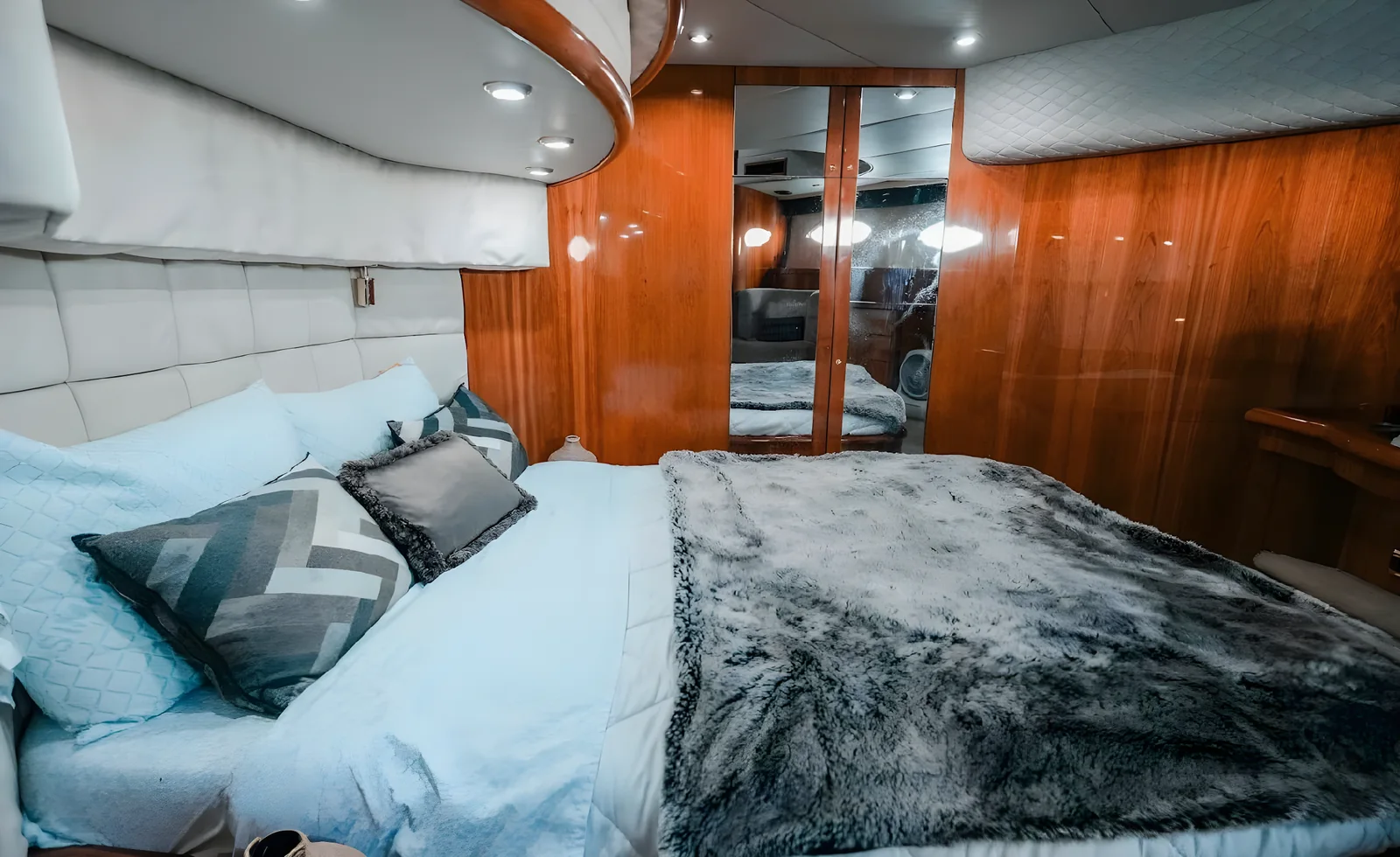 Cabina principal del yate Gambler de 75 pies con armario espejado y paredes de madera.