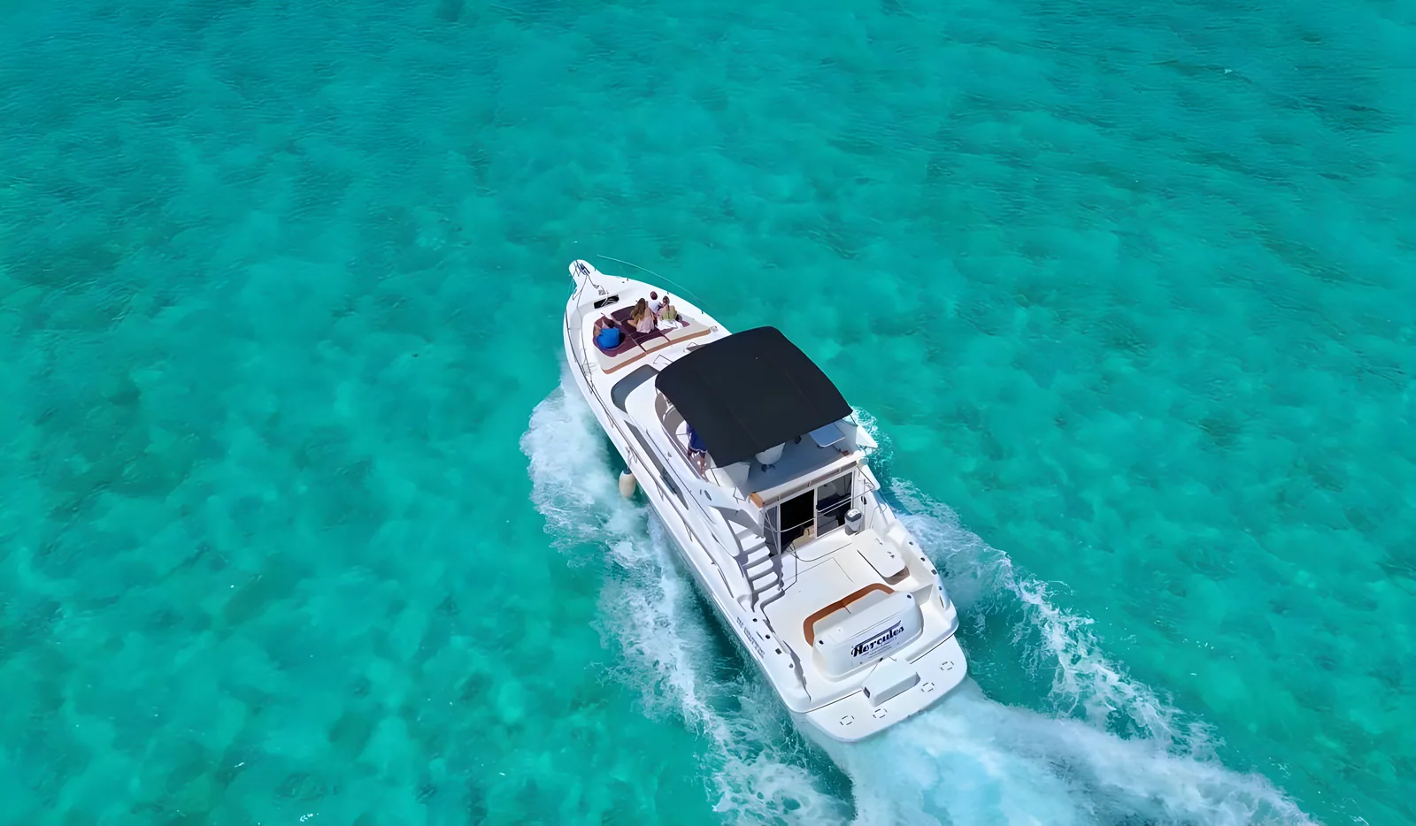 Vista aérea de la popa del yate Hercules 46ft Fly navegando sobre aguas turquesa.