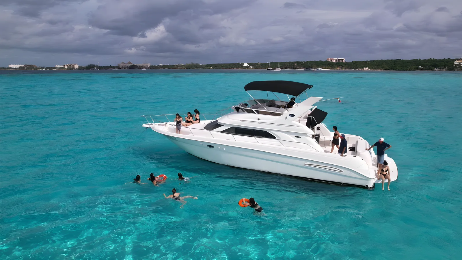 Perfil exterior del yate Hercules 46ft Fly fondeado con huéspedes nadando alrededor.