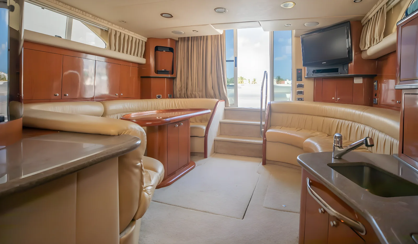Amplio salón del yate Hercules 46ft Fly con sofás, mesa y televisión a bordo.