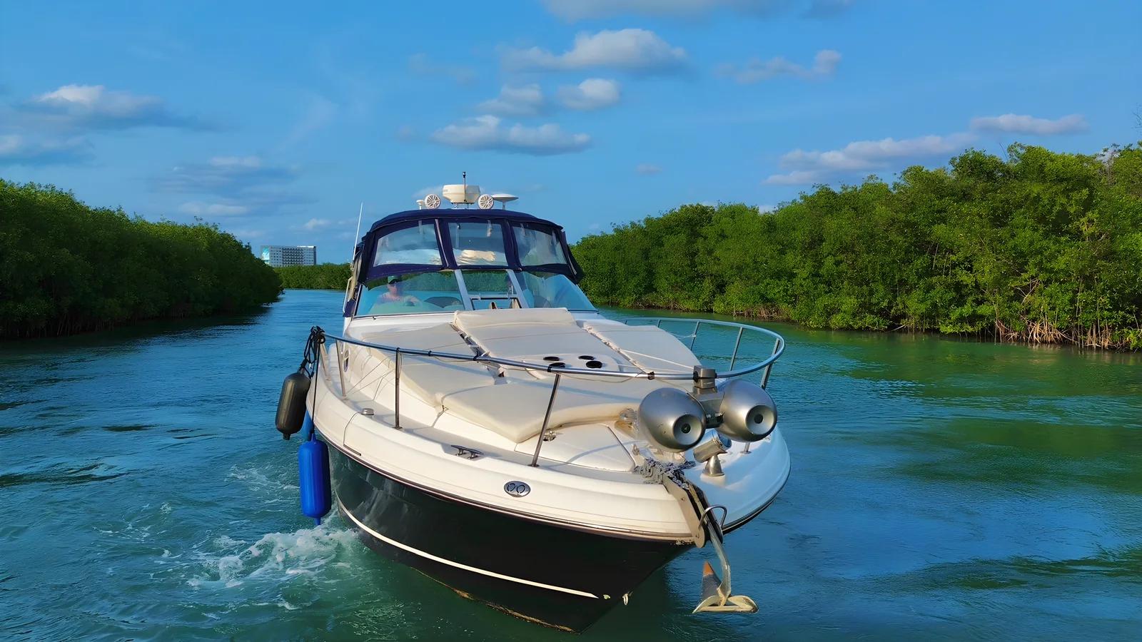 El yate Libélula de 37 pies avanzando por un canal entre manglares.