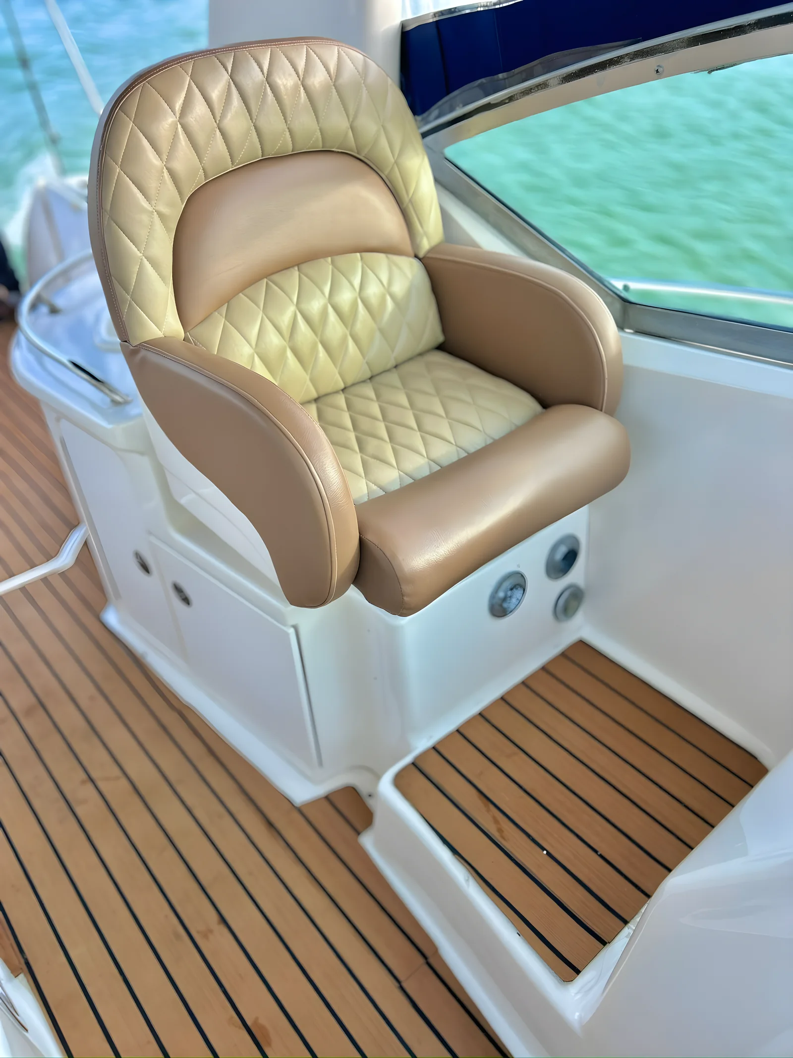 Asiento del timón acolchado del yate Libélula de 37 pies con detalles de cuero y cubierta de teca.
