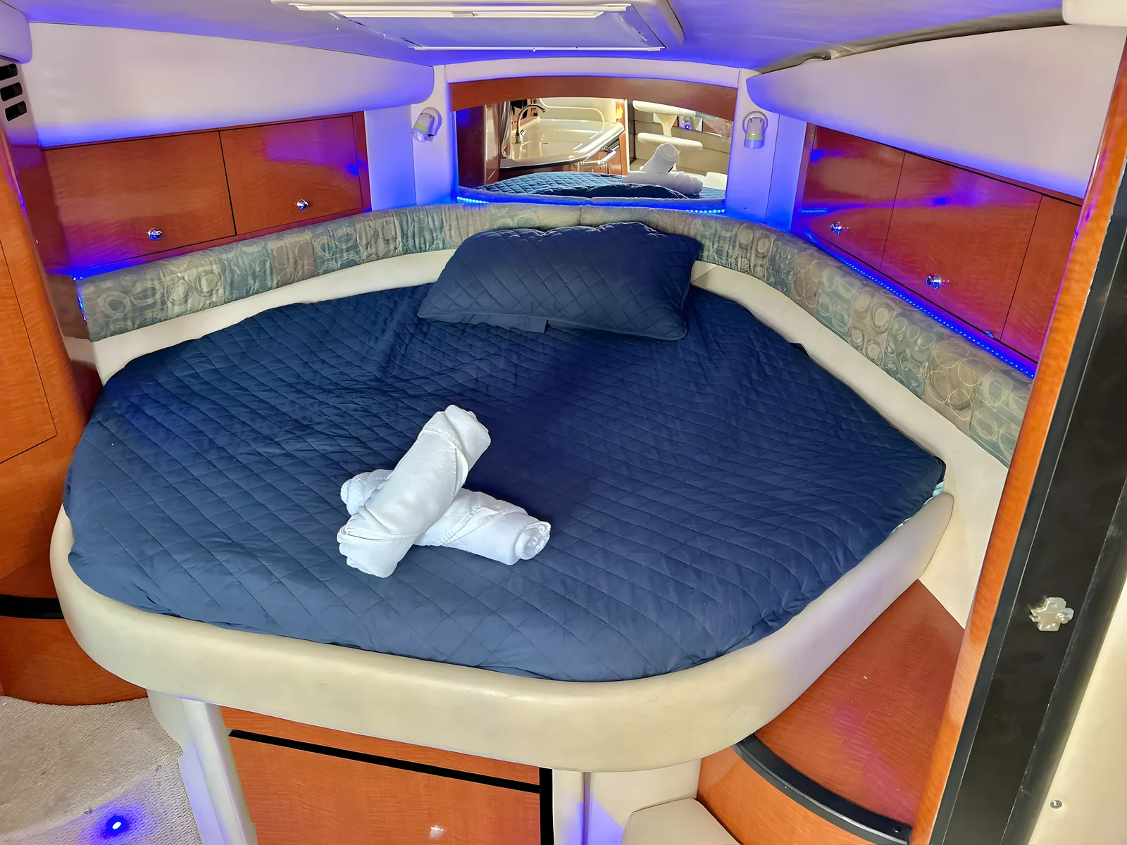Camarote principal del yate Libélula de 37 pies con cama redonda y ambientación en madera.