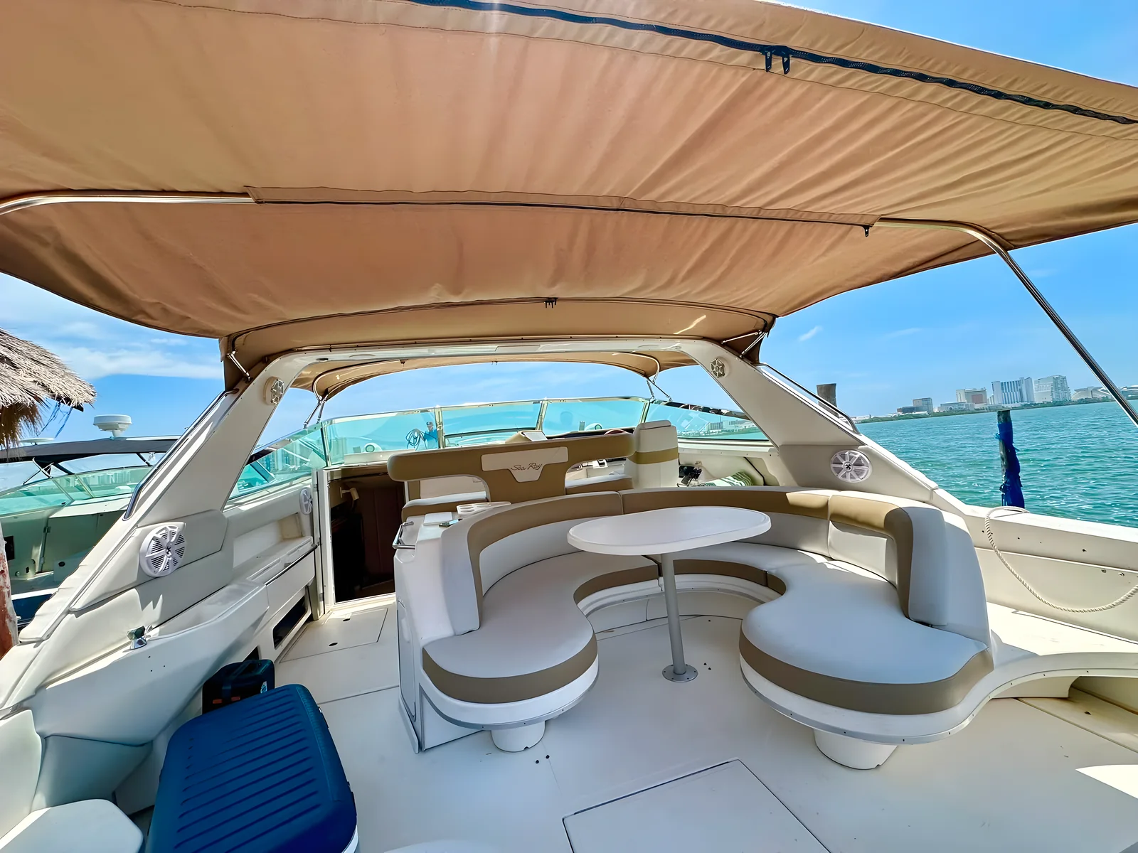 Cubierta trasera del yate Life Is Now de 50 pies con asientos en U bajo toldo y vistas al mar.