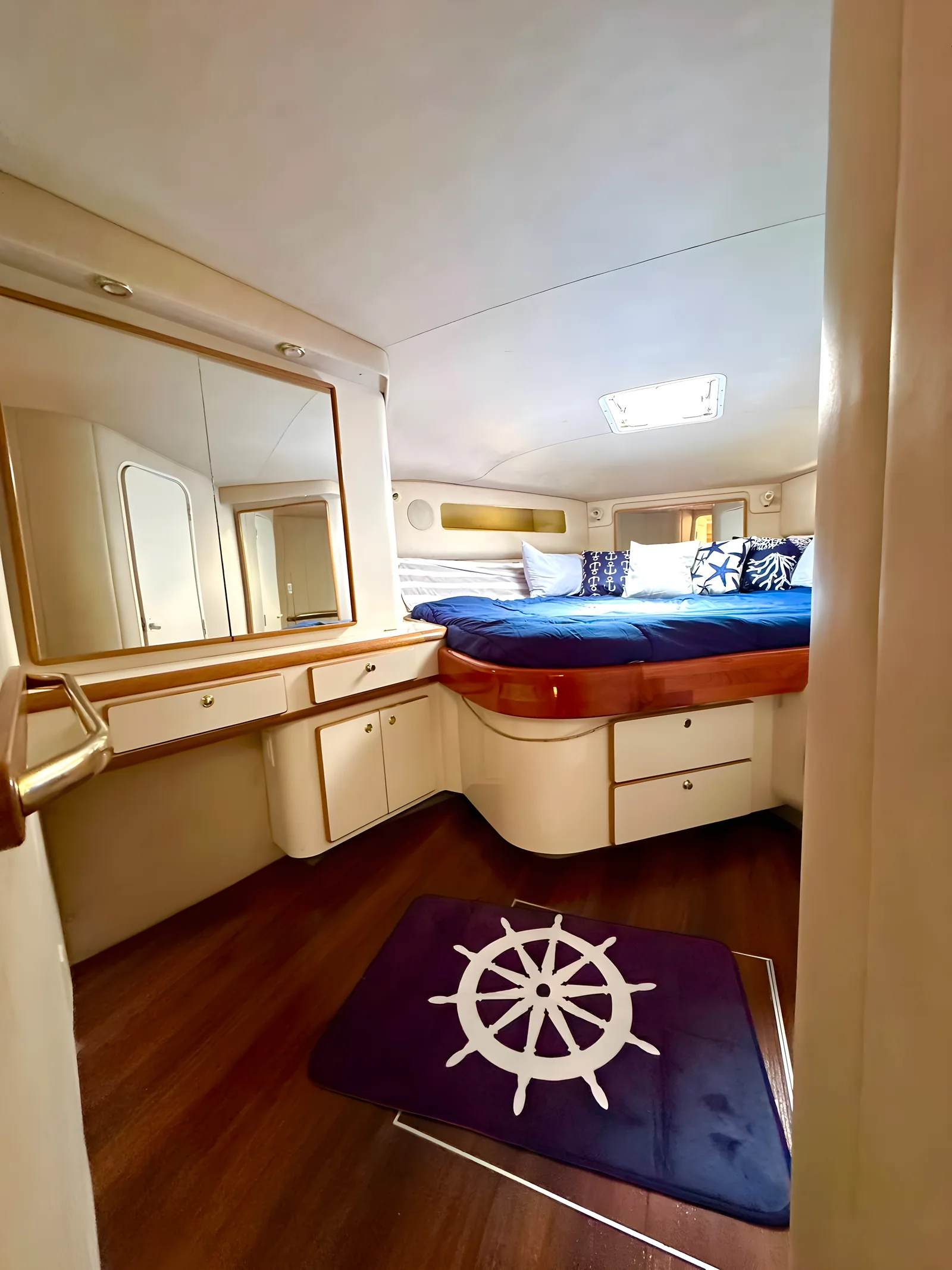 Cabina principal del yate Life Is Now de 50 pies con cama doble, tocador con espejo y detalles en madera.
