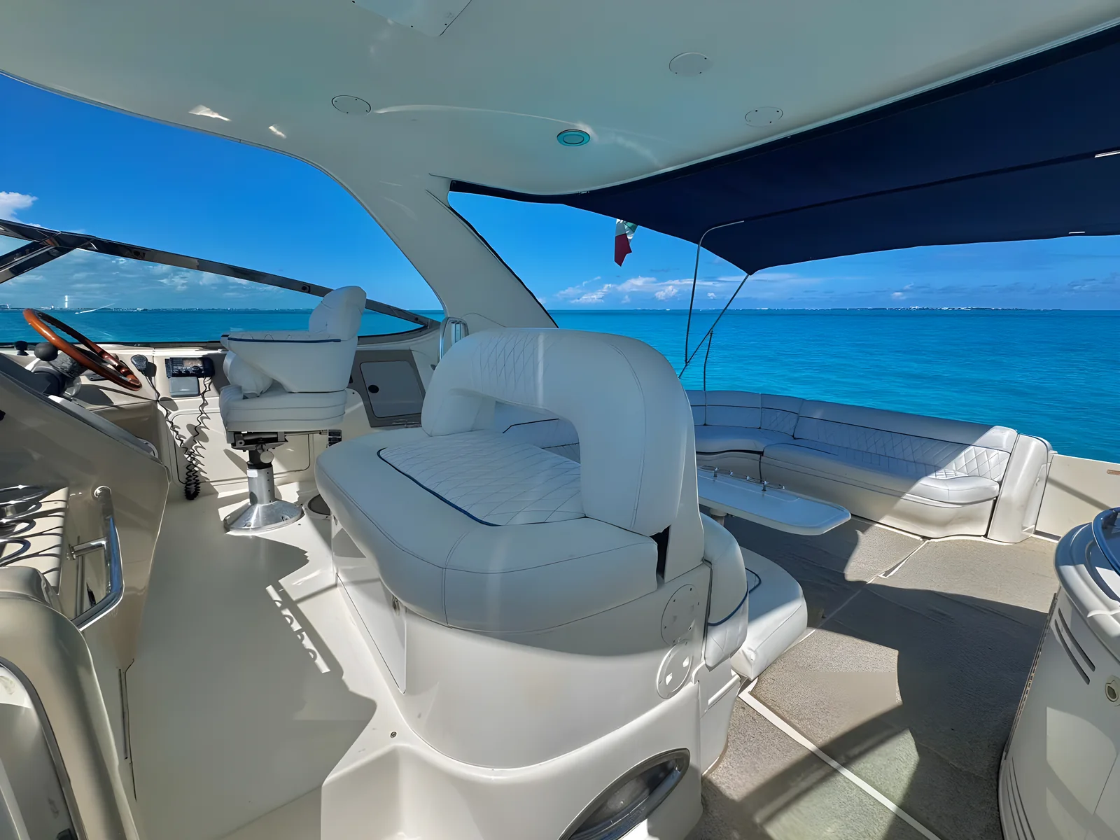 Timonela del yate Seawhale de 60 pies con asientos blancos y vista al mar.