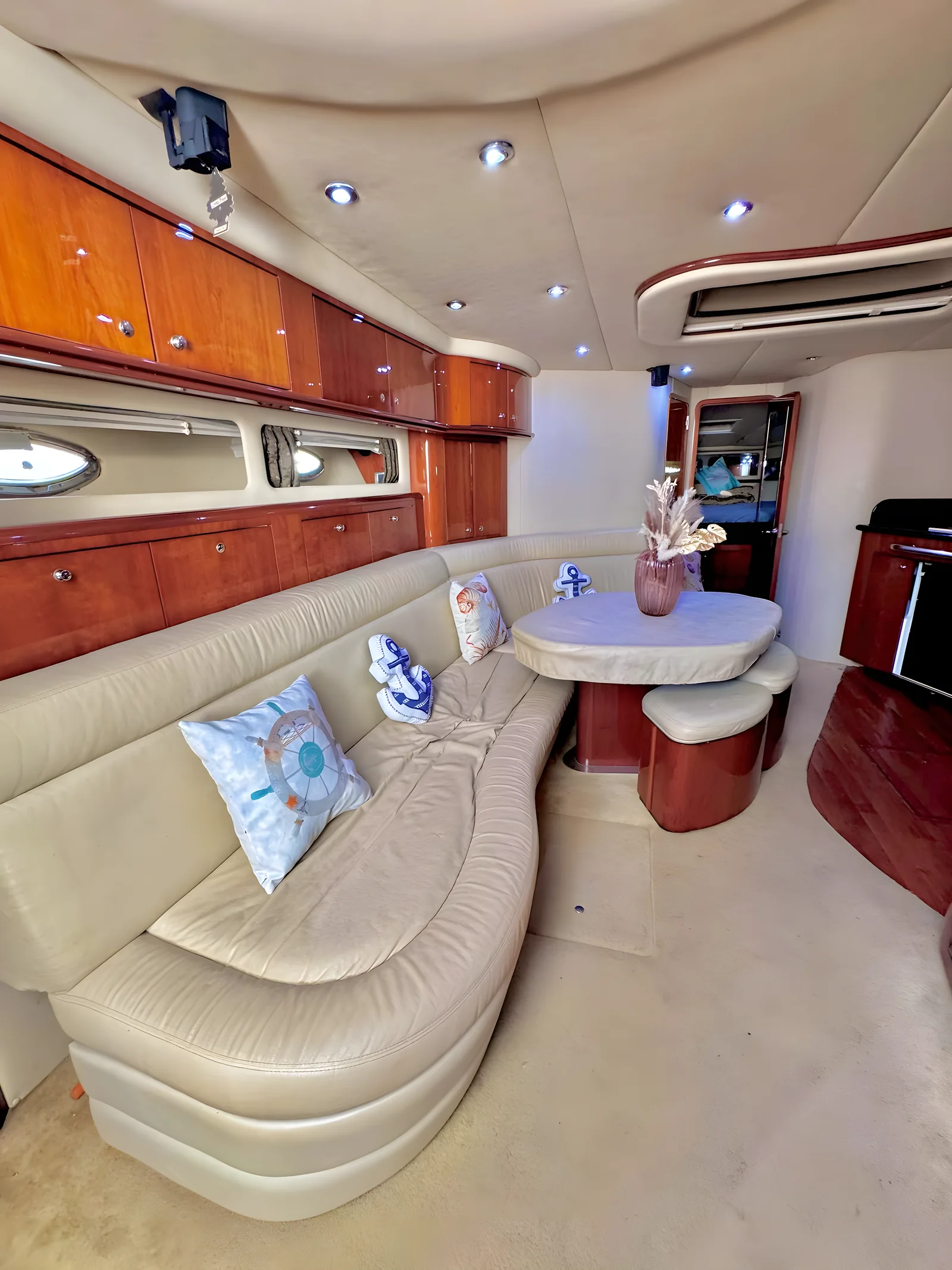 Salón interior amplio del yate Tritón de 60 pies con sofá, mesa y televisión.