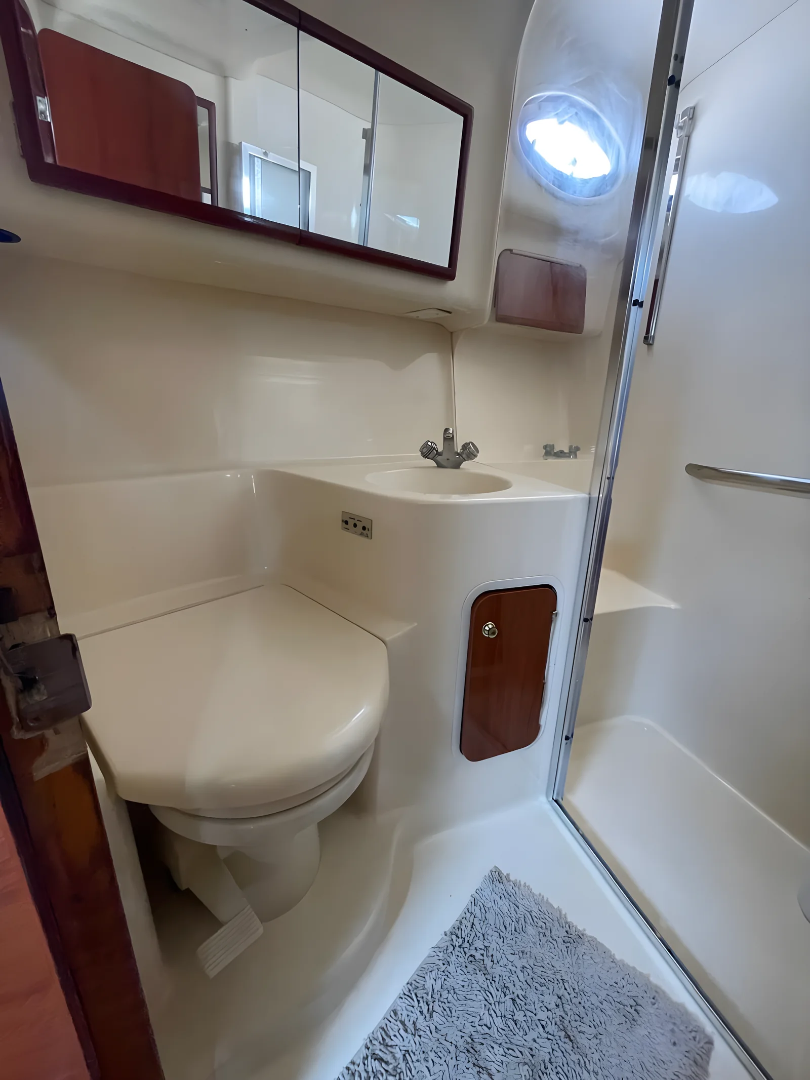 Baño compacto con ducha, inodoro y lavamanos en el yate University Drop Out.