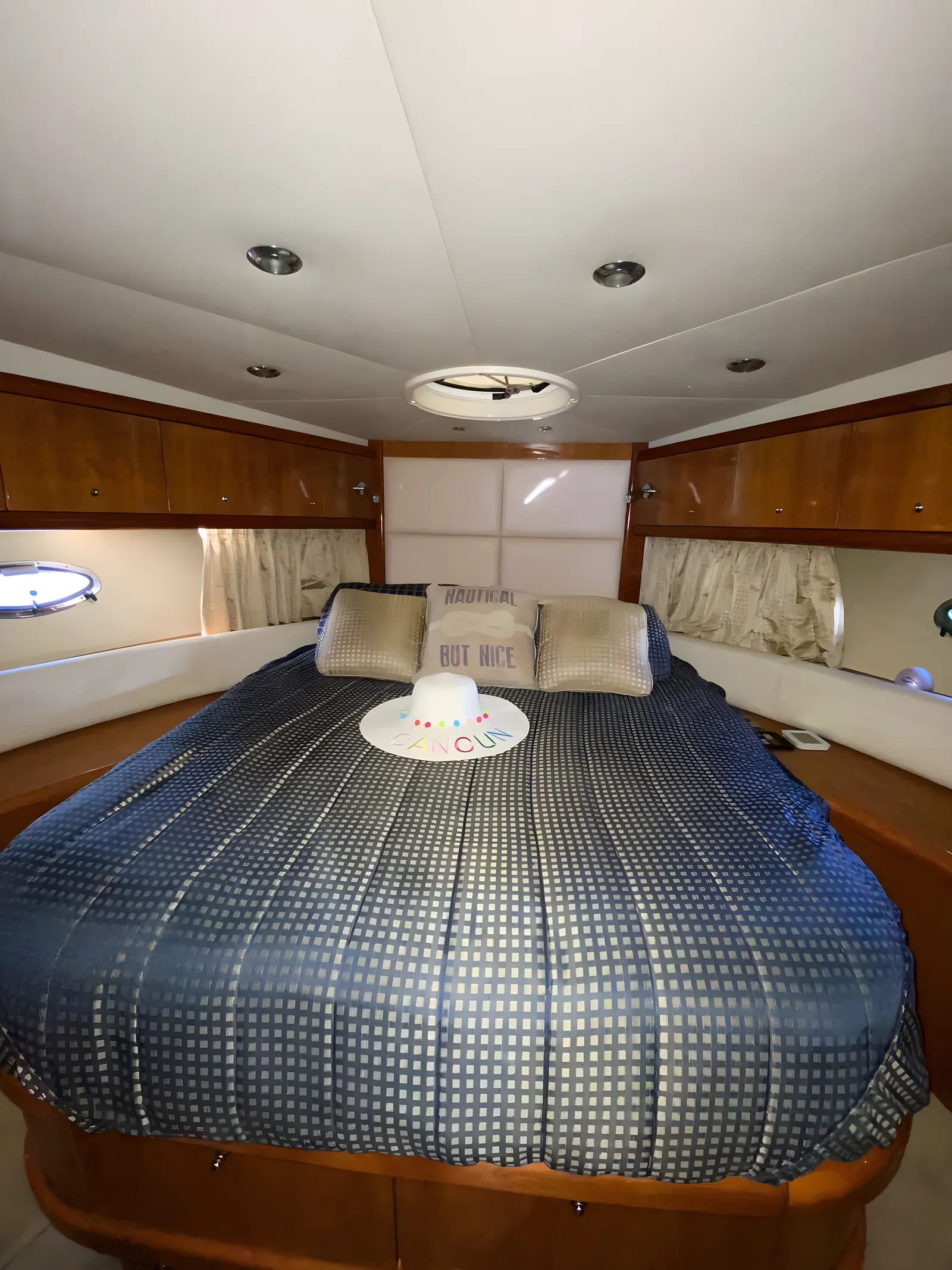 Cabina principal del yate YOLO de 50 pies con cama circular y almohadas decorativas.